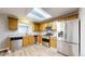 Well-lit kitchen with light wood cabinets, stainless steel appliances, and skylight provides plenty of natural light at 5308 S Ukraine St, Aurora, CO 80015