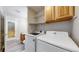 Functional laundry room with modern appliances and overhead storage, offering convenience and efficiency at 5308 S Ukraine St, Aurora, CO 80015