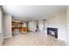 Spacious living area with an open layout featuring fireplace and view into the kitchen at 5308 S Ukraine St, Aurora, CO 80015