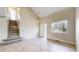 Open-concept living area with staircase, large window, and neutral tile flooring at 5308 S Ukraine St, Aurora, CO 80015