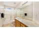 Bright bathroom with a large mirror, granite countertop, and shower-tub combination with sliding glass doors at 16478 Marion St, Thornton, CO 80602