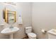 Powder room with a pedestal sink and modern fixtures plus views to the main bathroom at 16478 Marion St, Thornton, CO 80602