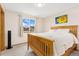 Cozy bedroom with a wooden bed frame, a large window, and soft natural light at 16478 Marion St, Thornton, CO 80602