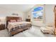 Main bedroom features a large window with views, neutral decor, and closet storage at 16478 Marion St, Thornton, CO 80602