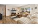 Bright living room featuring hardwood floors, large windows, and comfortable neutral furniture at 16478 Marion St, Thornton, CO 80602