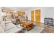 Open-concept living room with hardwood floors that flows into the kitchen and dining area at 16478 Marion St, Thornton, CO 80602