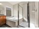 Bright bathroom featuring a soaking tub, and glass enclosed shower at 368 Dallas St, Denver, CO 80230