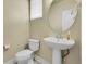 Stylish powder room with a pedestal sink, round mirror and neutral tones at 368 Dallas St, Denver, CO 80230