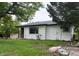 Well-maintained single-story home with white siding, manicured lawn, and updated windows for enhanced curb appeal at 5008 Alcott St, Denver, CO 80221