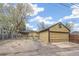 View of a detached one-car garage with a long driveway and backyard beyond at 5008 Alcott St, Denver, CO 80221