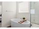 Bright bathroom featuring a standalone tub with a wooden tray, a shower, and a window at 5861 Tesoro Pt, Parker, CO 80134