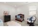 Cozy Bedroom with a wooden crib, a dark dresser, a rocking chair, and a window that provides natural light at 5861 Tesoro Pt, Parker, CO 80134