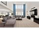 Bright, open living room with tall ceilings, large windows, and comfortable gray sectional couch at 5861 Tesoro Pt, Parker, CO 80134