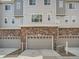 This townhome has a three-car garage with brick exterior, offering ample parking at 5435 W 97Th Pl, Broomfield, CO 80020