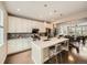 Elegant kitchen with white cabinetry, stainless steel appliances, a large island, and hardwood floors at 5435 W 97Th Pl, Broomfield, CO 80020