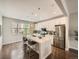 Bright kitchen with white cabinets, stainless appliances, an island with seating, and hardwood floors at 5435 W 97Th Pl, Broomfield, CO 80020
