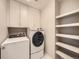 Well-equipped laundry room with washer, dryer, and built-in shelving at 5435 W 97Th Pl, Broomfield, CO 80020