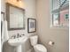 The powder room features a pedestal sink, decorative mirror, and modern fixtures at 5435 W 97Th Pl, Broomfield, CO 80020