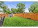 Well-maintained backyard with a play structure, fenced yard, and lush green grass for outdoor enjoyment at 2967 Olive St, Denver, CO 80207