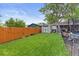 Grassy backyard is fully fenced with a storage shed and space for outdoor activities at 2967 Olive St, Denver, CO 80207