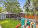 Lush backyard with mature trees, playset, trampoline, and covered patio offers ample space for recreation at 2967 Olive St, Denver, CO 80207