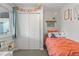 Bright bedroom with a comfortable bed, decor shelf, and a window that lets in natural light at 2967 Olive St, Denver, CO 80207