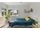 Bright bedroom featuring a large window, a ceiling fan, and a cozy bed with a blue comforter at 2967 Olive St, Denver, CO 80207