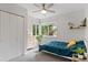 Bright bedroom featuring a large window, a ceiling fan, and a cozy bed with a blue comforter at 2967 Olive St, Denver, CO 80207