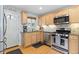 Modern kitchen with stainless steel appliances and warm wood cabinets at 2967 Olive St, Denver, CO 80207