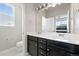 Bathroom featuring a double vanity, large mirror, and ample natural light at 6988 Ipswich Ct, Castle Pines, CO 80108