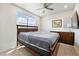 Bedroom with a ceiling fan, wooden furniture, and a large window offering natural light at 6988 Ipswich Ct, Castle Pines, CO 80108