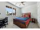 Bedroom featuring a ceiling fan, large window, and a wooden bed with navy bedding at 6988 Ipswich Ct, Castle Pines, CO 80108