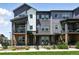 Beautiful townhouse with a black metal fence, landscaping, and a covered balcony at 6988 Ipswich Ct, Castle Pines, CO 80108