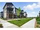 Townhouse exterior featuring gray siding, a well-manicured lawn, and a sidewalk at 6988 Ipswich Ct, Castle Pines, CO 80108