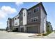 Modern townhome exterior with gray siding, white accents, and attached garages at 6988 Ipswich Ct, Castle Pines, CO 80108