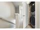 Hallway with carpet and white doors, featuring a stacked washer and dryer unit at 6988 Ipswich Ct, Castle Pines, CO 80108