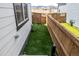 Side yard between two homes featuring artificial turf, and a wooden fence at 8358 Howell St # B, Arvada, CO 80005