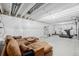 Partially finished basement featuring a large sectional, gym equipment, and a large open space at 8358 Howell St # B, Arvada, CO 80005