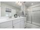 Bright bathroom features a double vanity with white quartz countertops and a glass-enclosed shower at 8358 Howell St # B, Arvada, CO 80005