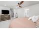 Comfortable primary bedroom with a tufted headboard, ceiling fan, and decorative dresser at 8358 Howell St # B, Arvada, CO 80005