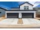 Home's exterior features a two car garage, white siding, black trim and rock landscaping at 8358 Howell St # B, Arvada, CO 80005