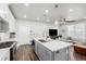 Modern kitchen with island, quartz countertops, stainless steel appliances, and adjacent living room area at 8358 Howell St # B, Arvada, CO 80005