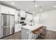 Modern kitchen features white cabinets, stainless steel appliances, and a large island with seating at 8358 Howell St # B, Arvada, CO 80005