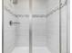 Glass-enclosed shower boasts decorative tiling and a sleek shower head with a built in shelf at 8358 Howell St # B, Arvada, CO 80005