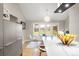 Bright dining area with large windows overlooking the exterior, stainless steel fridge, and hardwood floors at 32399 Woodland Dr, Evergreen, CO 80439