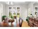 Bright dining room with large windows overlooking the exterior and an antique-style wooden table with six chairs at 32399 Woodland Dr, Evergreen, CO 80439