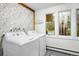 Laundry room with side-by-side white appliances and views of the trees outside the windows at 32399 Woodland Dr, Evergreen, CO 80439