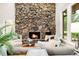 Inviting living room featuring a stone fireplace, neutral-toned furnishings, and hardwood floors at 32399 Woodland Dr, Evergreen, CO 80439