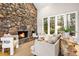 Cozy living room featuring a stone fireplace, neutral-toned furnishings, and hardwood floors at 32399 Woodland Dr, Evergreen, CO 80439