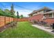 Grassy backyard features a patio with outdoor dining area and a high wooden fence at 6011 Welch St, Arvada, CO 80004